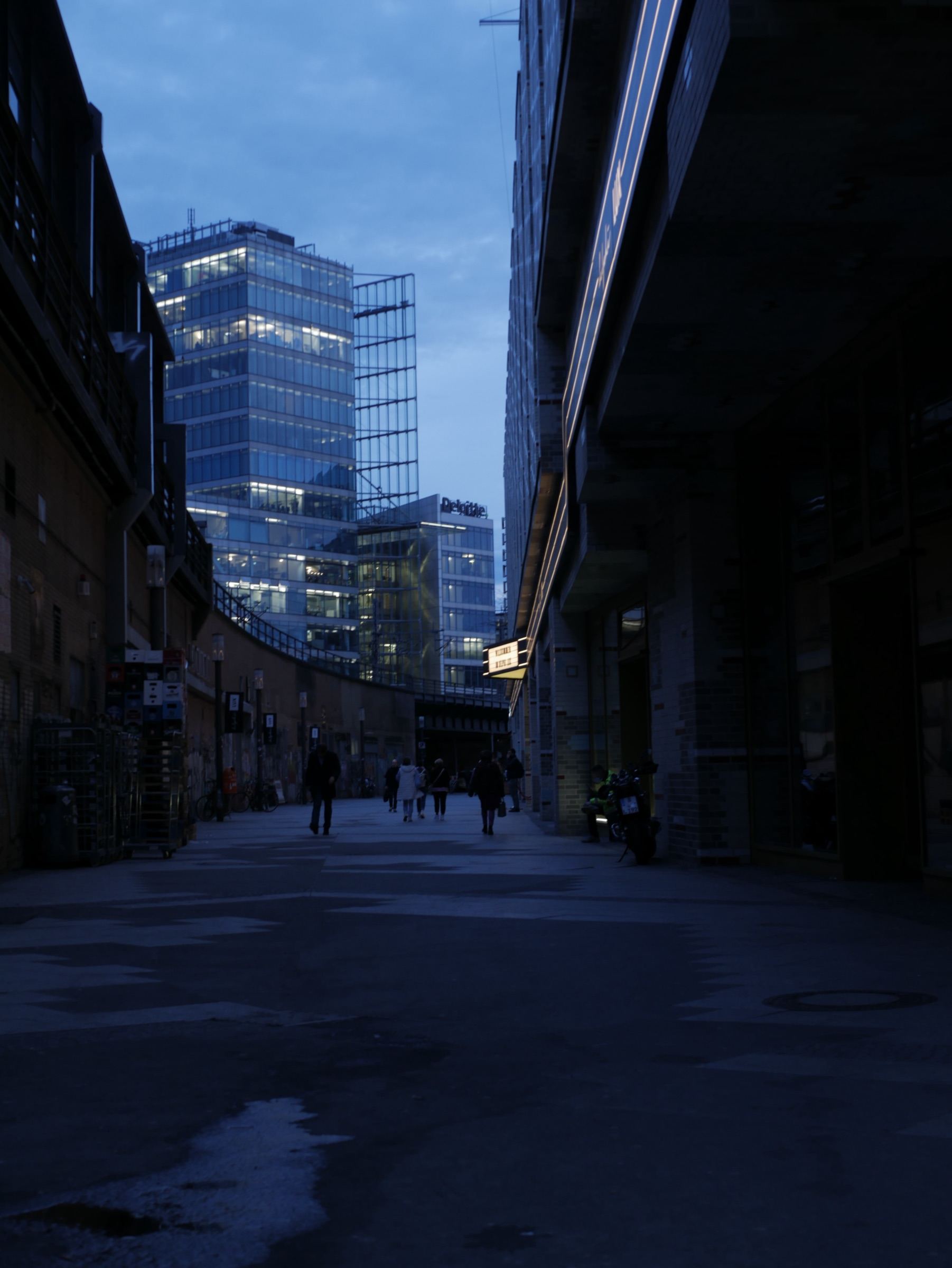 Calle urbana al atardecer con rascacielos iluminados